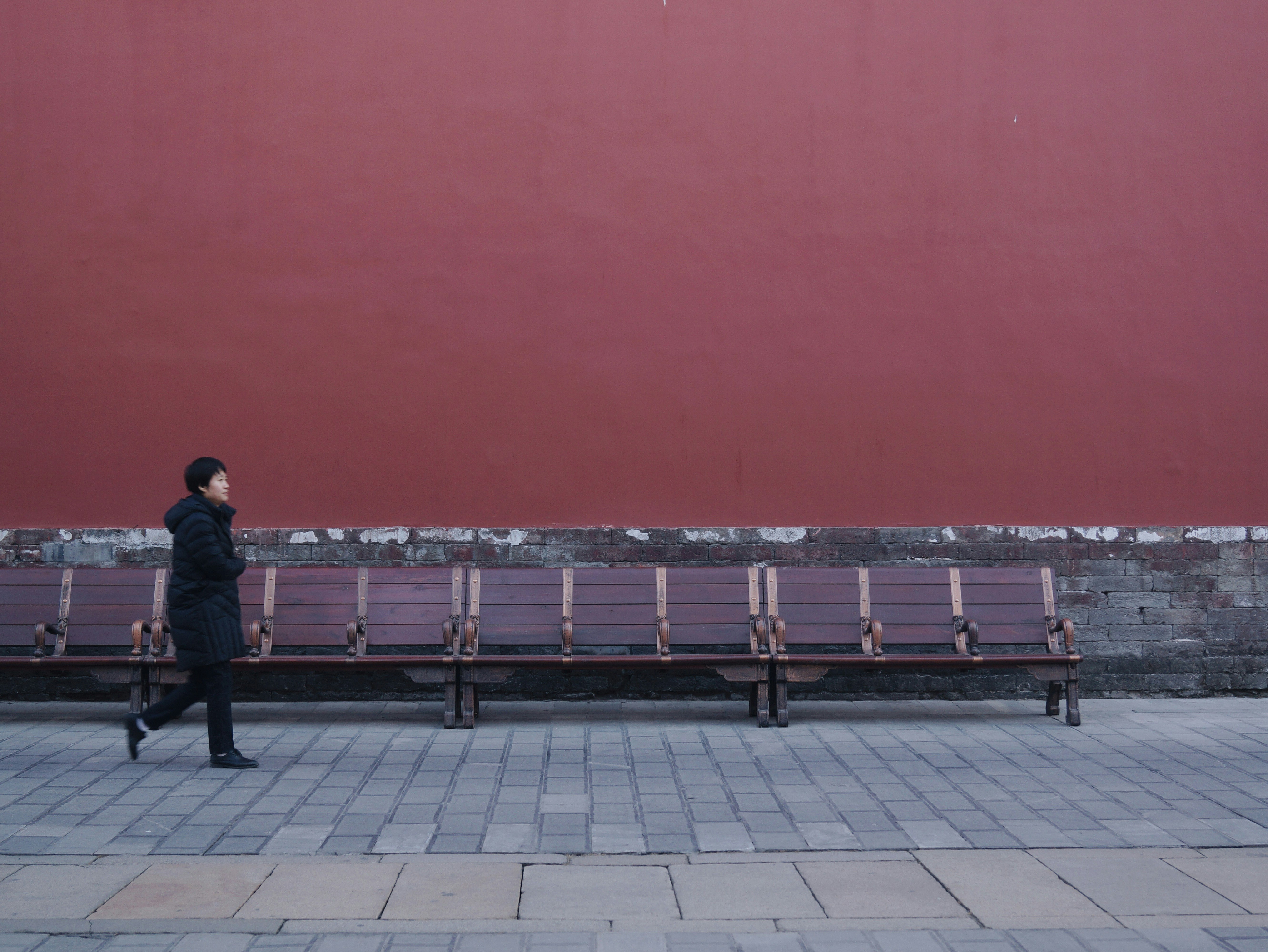 woman walking beside bench